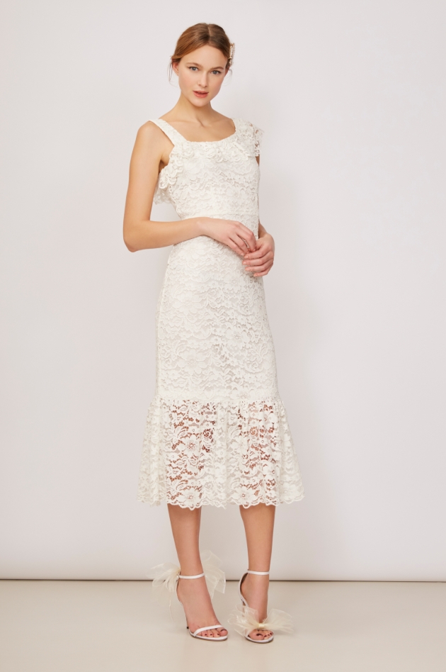 Model is in a studio and wearing an ivory floral lace dress 