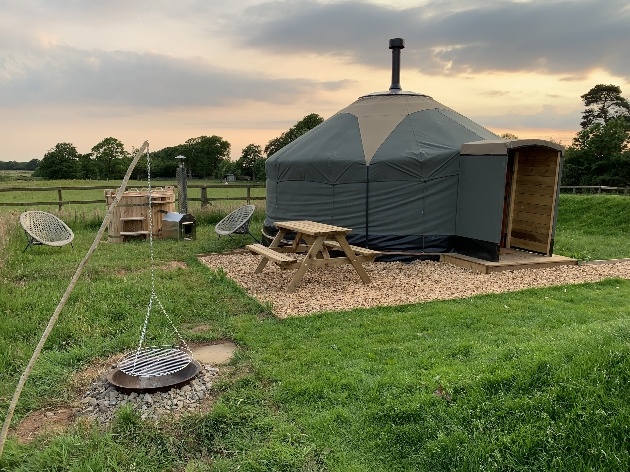 yurt with chimney tables and chairs hot tub and fire pit