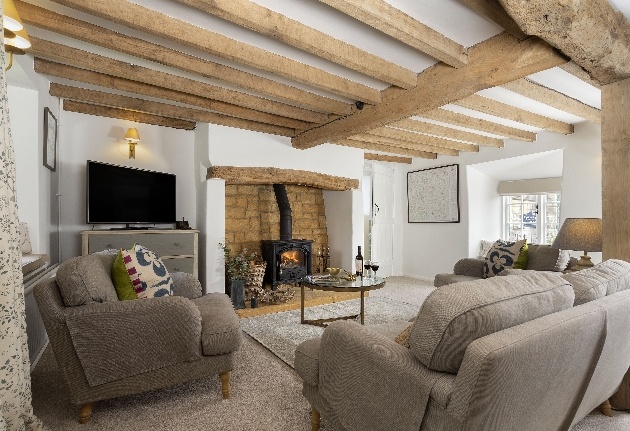 cosy lounge cream sofas woodburner beams on ceiling