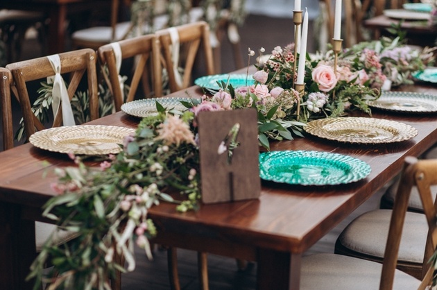 Wedding table dressed with bohemian foliage and flowers.