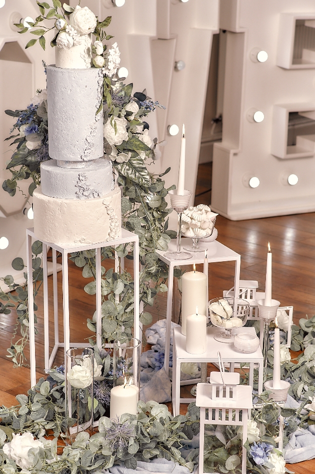 dusky blue wedding cake and sweet treats on plinths of varying heights