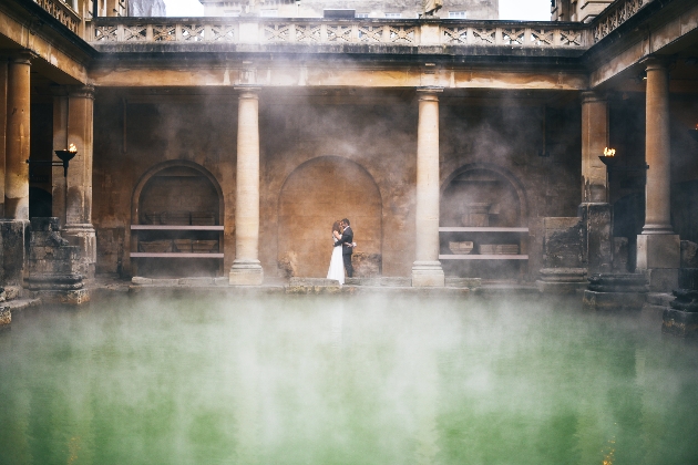 Bride and groom seen through the steam arising from the Roman Baths