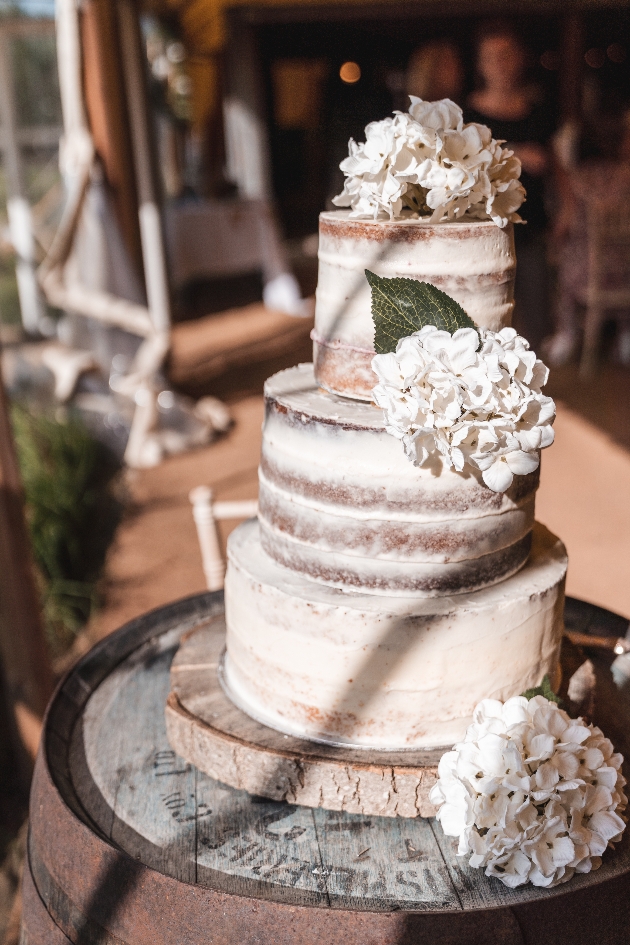 Semi-naked wedding cake with white flowers