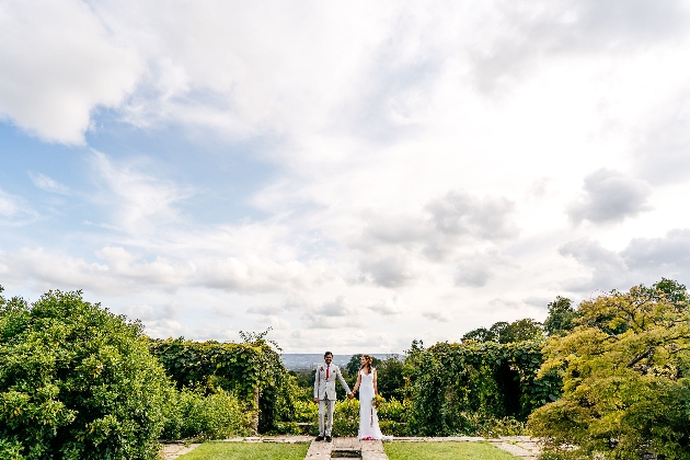 Couple holding hands surrounded by beautiful gardens