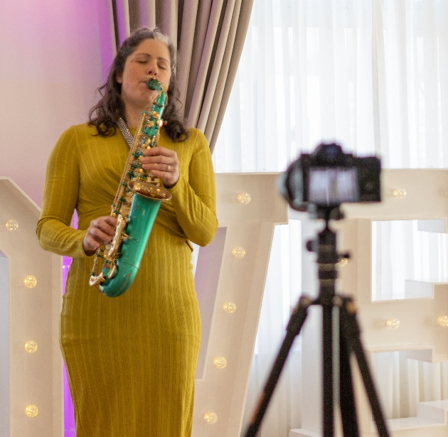 Lucy harvey playing sax inside the venue for her new vid