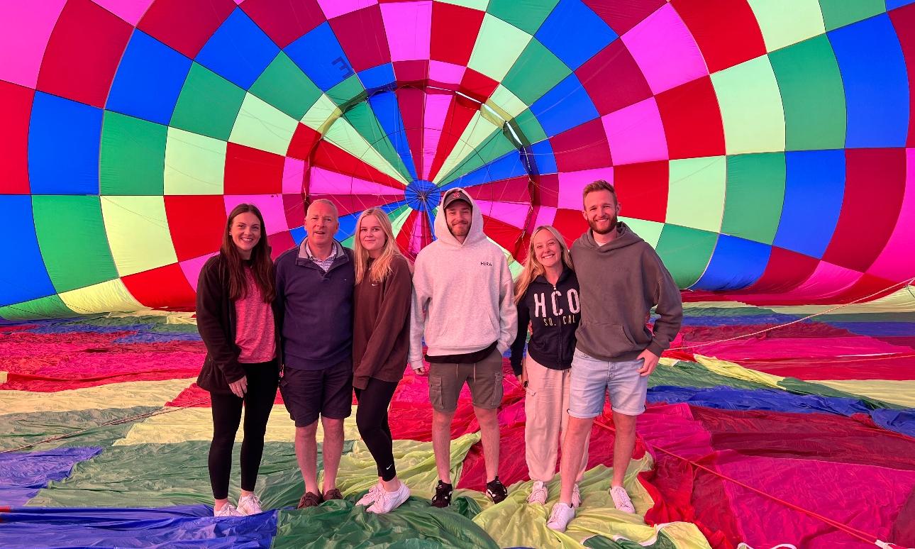 Group of people inside a colourful hot air balloon