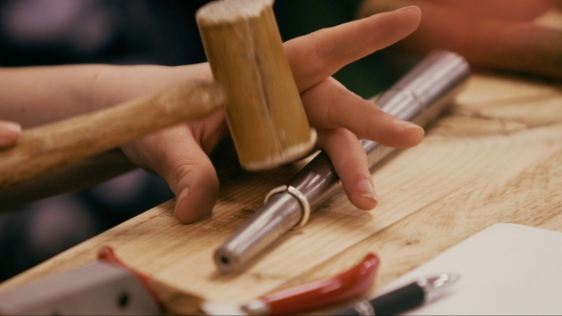 Jewellery maker hammering a ring into shape on a ring form