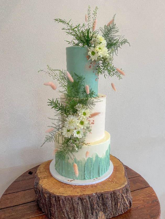 Duck egg blue/green three-tier wedding cake decorated with flowers